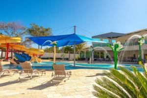 una piscina con sillas y sombrillas al lado de una piscina en diRoma Resort direto com o Grupo diRoma com acesso ao Acqua Park e Café da manhã, en Caldas Novas