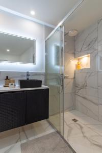 a bathroom with a glass shower and a sink at Siloé - Balnéo - Stationnement gratuit dans la rue- Gare 10 min à pied in Troyes