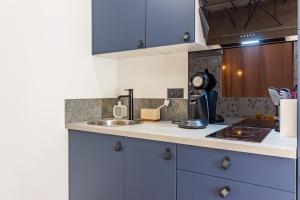 une cuisine avec des armoires bleues et un évier dans l'établissement Siloé - Balnéo - Stationnement gratuit dans la rue- Gare 10 min à pied, à Troyes