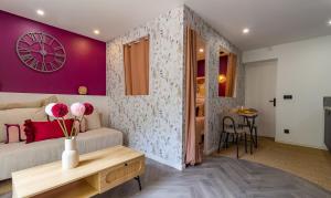 a room with a couch and a table with flowers on it at Siloé - Balnéo - Stationnement gratuit dans la rue- Gare 10 min à pied in Troyes