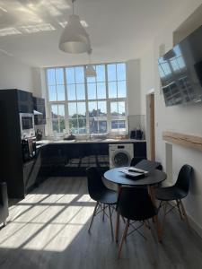 a kitchen with a table and chairs in a room at Stylish modern 2 bedroom flat 6B in Denton