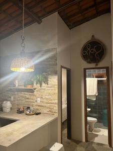 un bagno con un dipinto di un water e una luce di Casa Mahalo a Galinhos Altre 14 foto