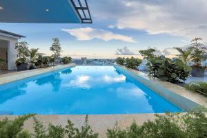 a large swimming pool with blue water and plants at Upscale Centric Apt, City Views in Santo Domingo