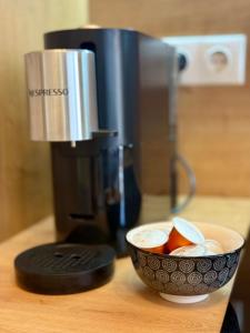 a coffee maker and a bowl of fruit on a counter at Apartment Ceasul Electric in Satu Mare