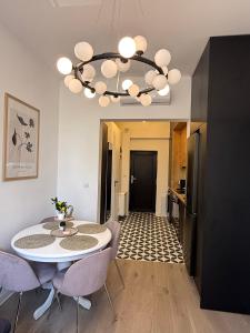 サトゥ・マーレにあるApartment Ceasul Electricのテーブルと椅子とシャンデリアのあるダイニングルーム +19枚の写真