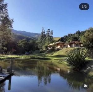 a view of a golf course with a pond at Pousada Sitio do Bau in São Bento do Sapucaí