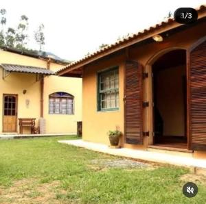 a house with a large yard in front of it at Pousada Sitio do Bau in São Bento do Sapucaí
