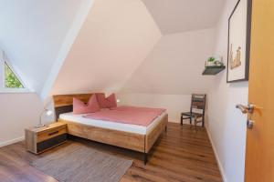 a bedroom with a bed with pink pillows on it at Ferienwohnung Strand in Prerow