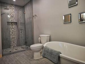 a bathroom with a tub and a toilet and a shower at Waterfront 3 Bedroom Home in Port McNicoll