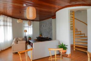 a living room with a couch and a staircase at African-style villa with lake view, sleeps 12 in Rwamagana