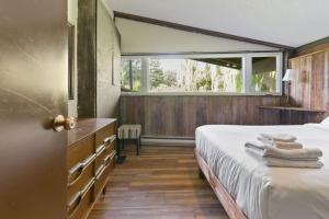a bedroom with a bed and a large window at Stunning Mountain Getaway with Open Concept Design in Blue Mountains