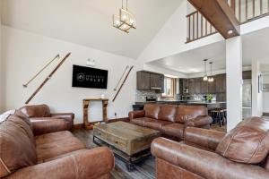 Il comprend un salon doté d'un mobilier en cuir et une cuisine. dans l'établissement 8 BR Luxury Swiss Style Chalet w Hot Tub, à Blue Mountains