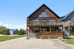 Cette grande maison en bois dispose d'une véranda et d'une terrasse. dans l'établissement 8 BR Luxury Swiss Style Chalet w Hot Tub, à Blue Mountains