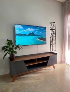 a flat screen tv sitting on top of a entertainment center at Cantinho Martins in Prado