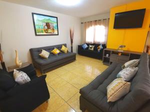 a living room with couches and a flat screen tv at Casa VILLA CUERVO PARA 21 PERSONAS in Tequila