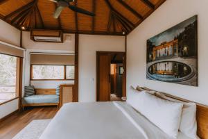 a bedroom with a white bed and a couch at Ahura 1BR Joglo with Views - 5 Min to Bingin Beach in Bingin Beach