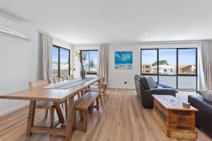 un soggiorno con un tavolo e un divano di Pebbles on Pascoe - Central apartment a Apollo Bay