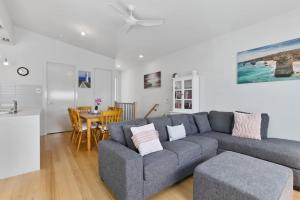 a living room with a gray couch and a table at SEASIDE 7 - Steps from the beach in Apollo Bay +11 photos