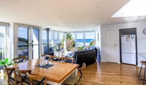 Una sala de estar con una mesa y sillas y el océano. en COASTAL HAVEN - panoramic ocean views, en Skenes Creek