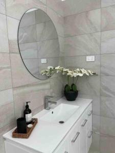 a bathroom with a white sink and a mirror at A Wave from It All Esperance in Esperance +19 photos