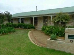 a brick house with a green roof and a driveway at A Wave from It All Esperance in Esperance