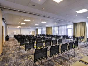 a conference room with chairs and a whiteboard at Novotel Poznań Malta in Poznań +162 photos