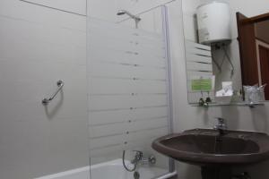 y baño con lavabo y bañera. en Hotel Vila Esteves en Monção