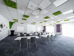 a conference room with tables and chairs and a screen at Ibis Styles Linz in Linz +156 photos