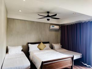a bedroom with two beds and a ceiling fan at Anilao Mabini Sea House Diveshop and Resort in Mabini