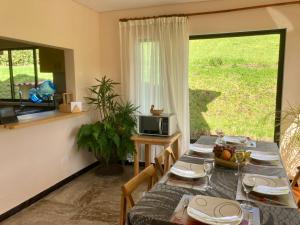 a dining room with a table and a television at Casa de Campo, chimi, jardin, terraza, montanas, cerca termales, reserva con anticipo in Guasca