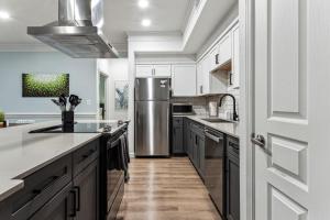 una cucina con armadi bianchi e frigorifero in acciaio inossidabile di Suite Life in Frisco, Luxury meets Comfort a Frisco