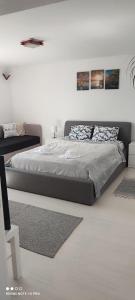 a bedroom with a large bed in a white room at Verebes Cottage with garden in Tuşnad