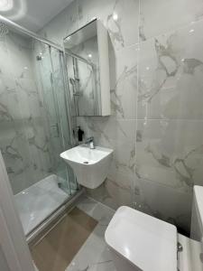 a bathroom with a sink and a shower and a toilet at Clapham Junction moments away in London