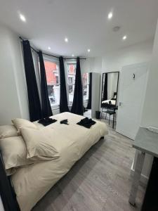 a bedroom with a large bed with black pillows on it at Clapham Junction moments away in London