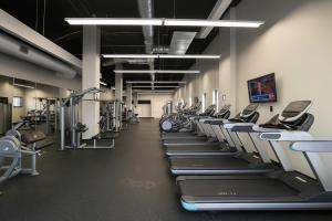 a gym with rows of treadmills and machines at Stylish Luxe Suite Rock Hall, Stadiums, Casino in Cleveland