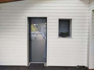 a white house with a door and two windows at Les hortensias in Lannion