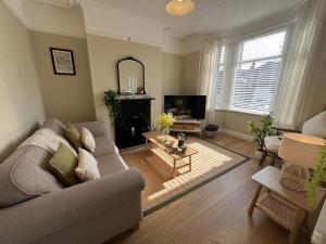 a living room with a couch and a table at Chic Welsh Escape Character Home in Newport