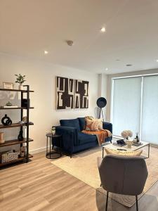 a living room with a blue couch and a table at Modern apartment in London in Dagenham Dock