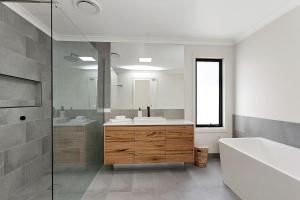 a bathroom with a tub and a sink and a shower at Benswan at the bay - 5 bedrooms in Apollo Bay +16 photos