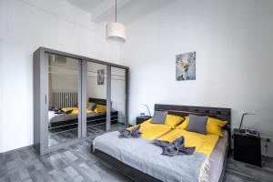 a bedroom with a large bed with yellow pillows at Budapest Panoramic Top-Floor Apartment with Citadella & Liberty Statue View in Budapest
