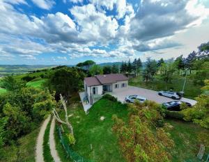 an aerial view of a house with cars parked in a yard at Villa immersa nei campi in Casal Fiumanese