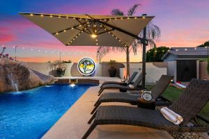 a backyard with a swimming pool with chairs and an umbrella at Northstar Zen Resort- Rock Waterslide - Pool - Spa - Secret Tunnel - Epic Game Room in Glendale