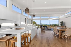 Una cocina y un comedor con mesa y sillas. en Cedar Tides - cedar hot tub, en Apollo Bay
