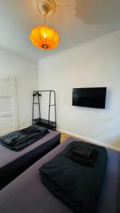 a room with two beds and a flat screen tv at 3-room apartment with parking space Sleepomat in Aschaffenburg +14 photos