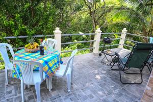 a table and chairs with a bowl of fruit on a patio at Kaz a jolive in Pointe-Noire
