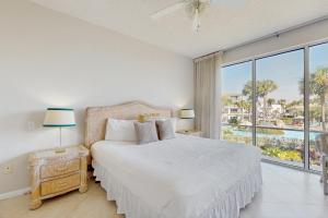 biała sypialnia z łóżkiem i dużym oknem w obiekcie High Pointe 235 w mieście Rosemary Beach +33 zdjęcia