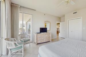 sypialnia z łóżkiem, telewizorem i krzesłem w obiekcie High Pointe 235 w mieście Rosemary Beach