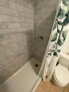 une salle de bain avec une baignoire, des toilettes et une douche dans l'établissement Toronto Central Stay Living Bloor, à Toronto