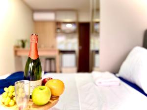 Una botella de vino y fruta en una mesa. en Studio aconchegante com piscina a 350m da praia, en Piçarras