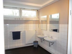 a bathroom with two sinks and two mirrors at Bergedorf Haus 9 in Hamburg